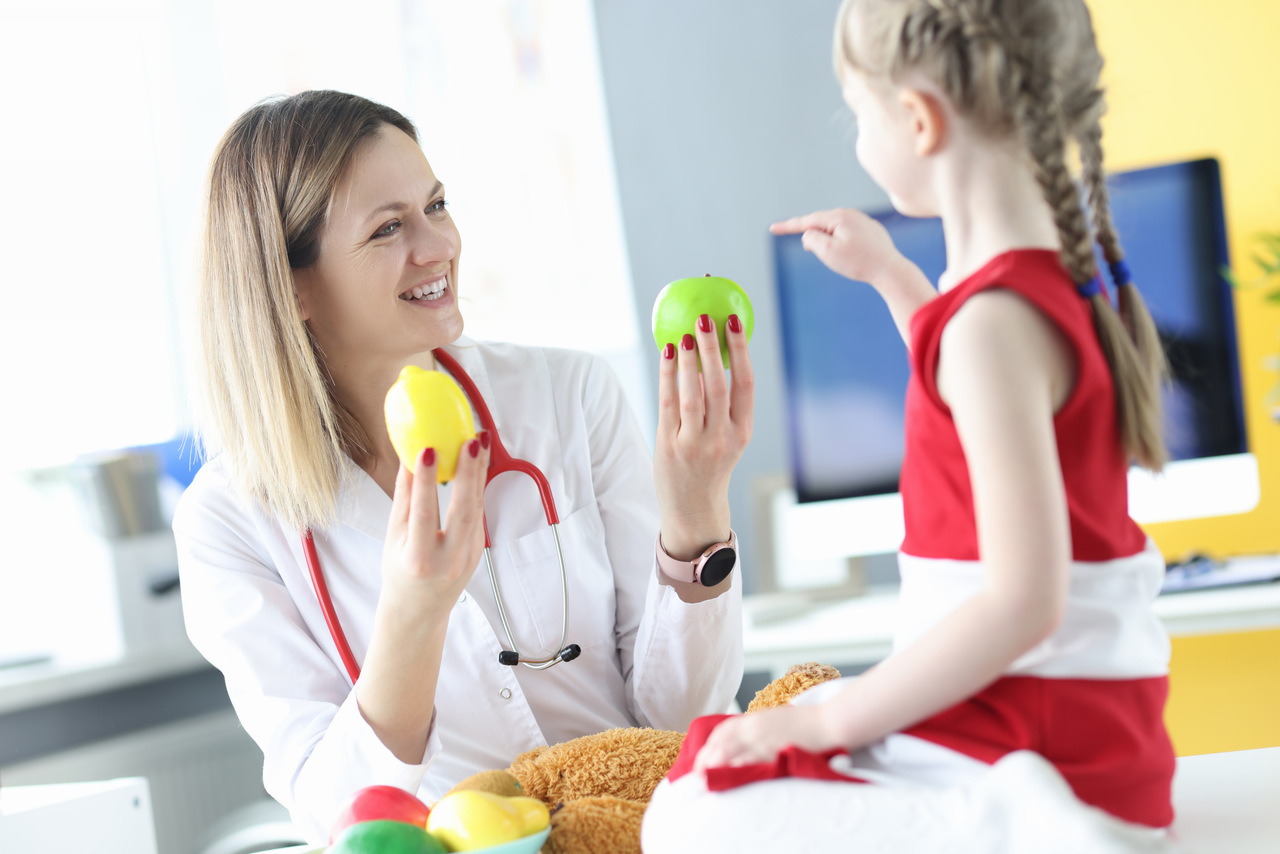 medica-dando-frutas-para-a-menina-na-clinica_Easy-Resize.com